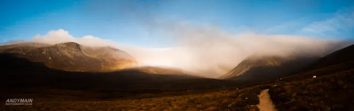 A rainbow half forms in the mist shrouding the massive.